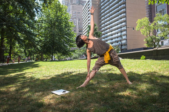 Jeune femme faisant du yoga dans le parc — Photo de stock