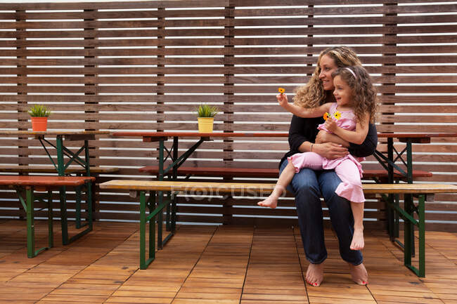 Mère et fille assises sur le banc sur le patio — Photo de stock