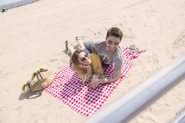 Сучасна пара добре проводить час, спираючись на пляж на ковдру — стокове фото