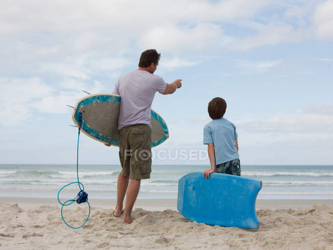 Pai e filho com prancha de surf e bodyboard — Fotografia de Stock