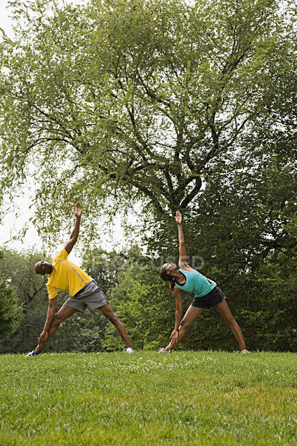 People doing yoga in park — Stock Photo
