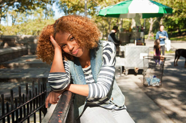 Mujer joven sentada en el parque, retrato - foto de stock