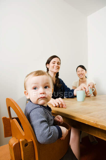 Un niño y una mujer se sentaron en una mesa - foto de stock