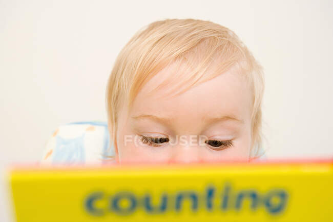 Bébé garçon regardant un livre — Photo de stock