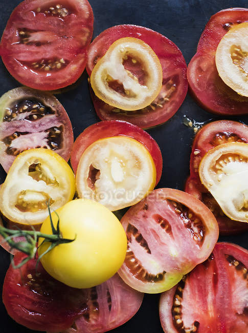 Still life of red and yellow sliced tomatoes, close up shot — Stock Photo