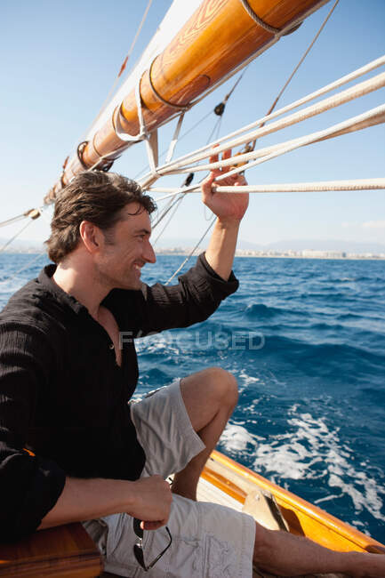 Людина тримається за мотузки на палубі — стокове фото