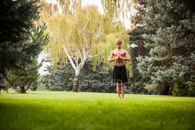 Man practicing yoga in park — Stock Photo