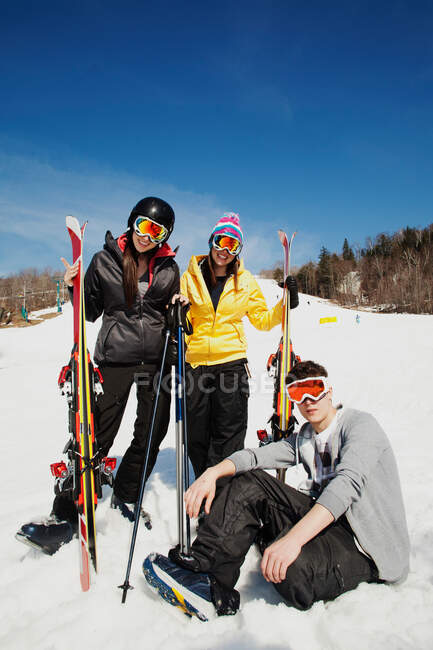 Trois amis portant des vêtements de ski avec des skis — Photo de stock