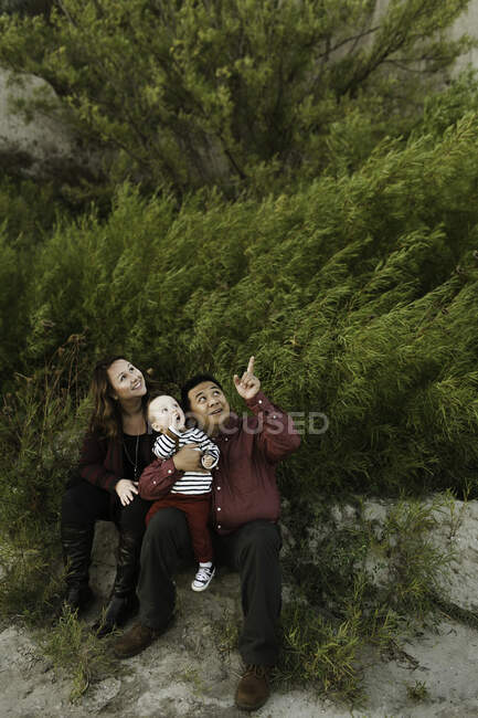 Familie mit Baby blickt nach oben und lächelt — Stockfoto