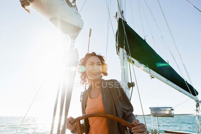 Young woman steering yacht — Stock Photo