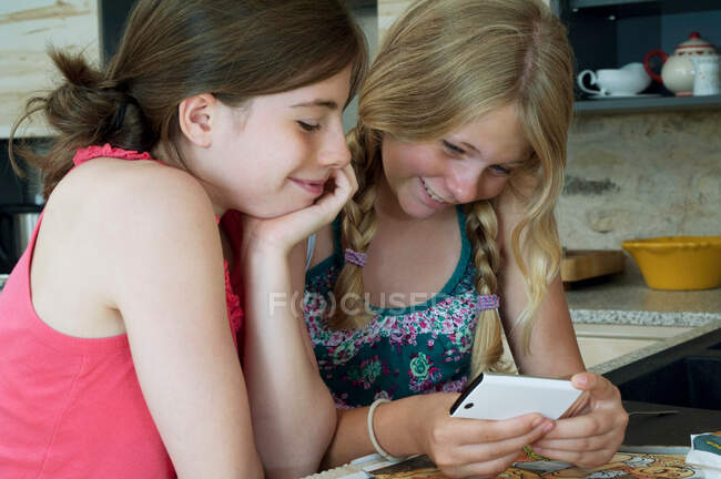 Две девушки смотрят на смартфон — стоковое фото