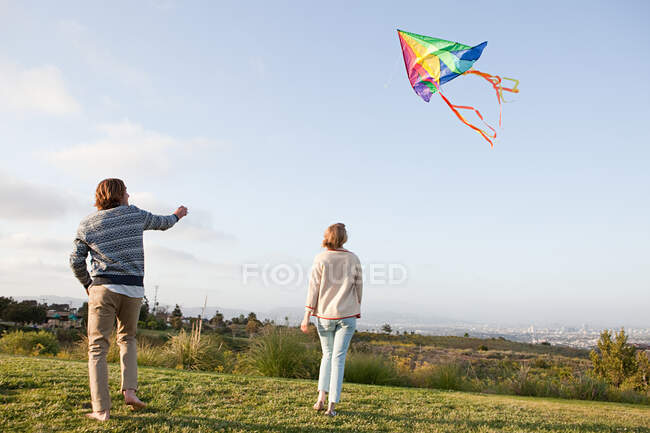 Молодая пара запускает воздушного змея — стоковое фото