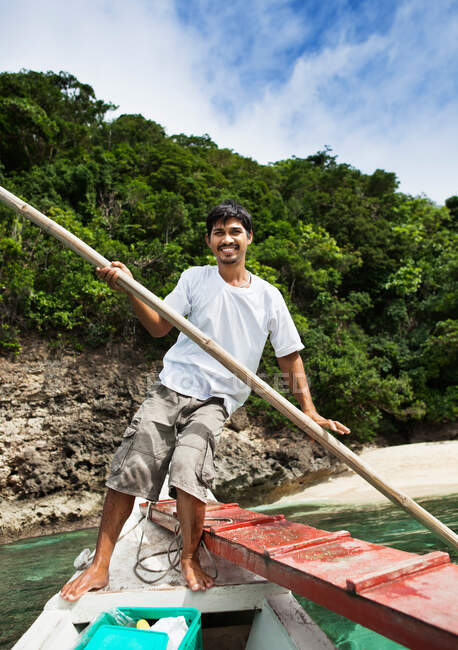 Homem remo barco em águas tropicais — Fotografia de Stock