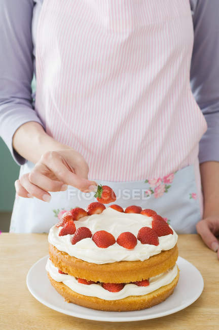 Cropped image of woman preparing cake with strawberries — Stock Photo