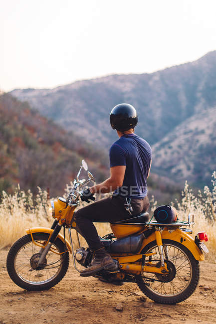 Людина сидить на мотоциклі, дивлячись на думку в Національний парк Секвойя, штат Каліфорнія, США — стокове фото