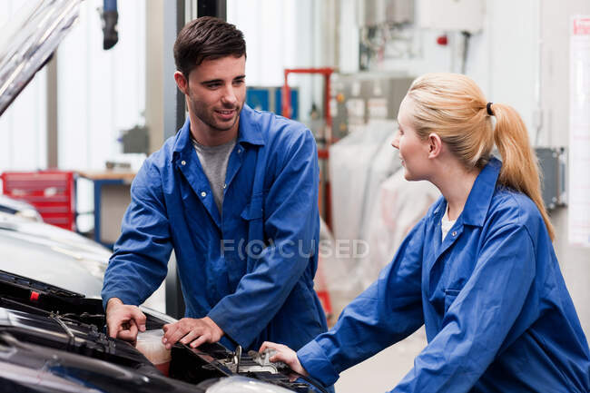 Mechanics discussing car engine — Stock Photo