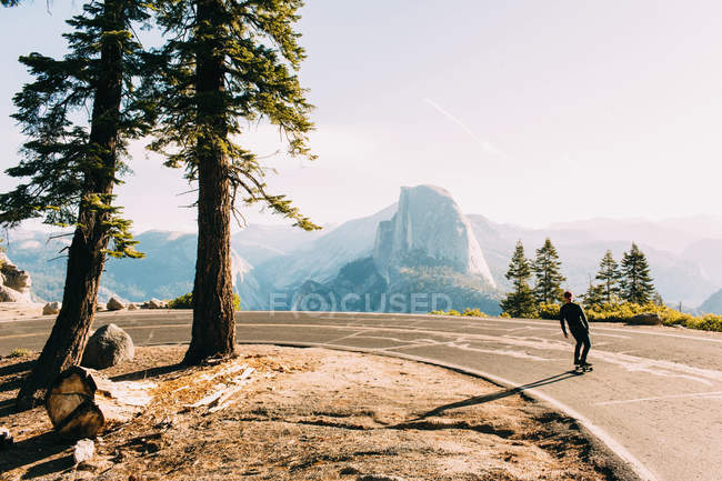 Skateboarder viajando em estrada de montanha, Yosemite, Califórnia, EUA — Fotografia de Stock