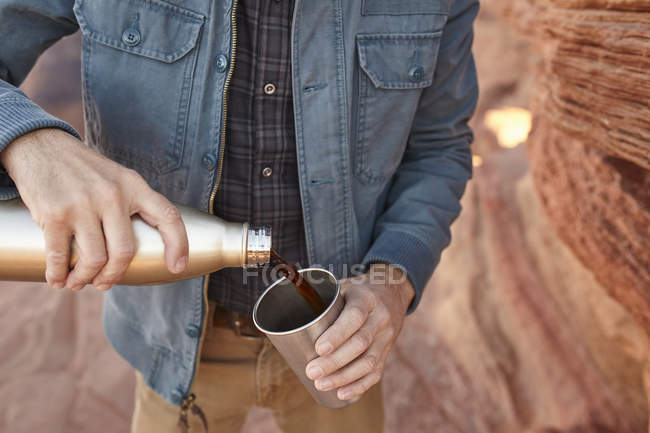 Мужчина, наливающий горячий напиток из питьевого фейка, Пейдж, Аризона, США — стоковое фото