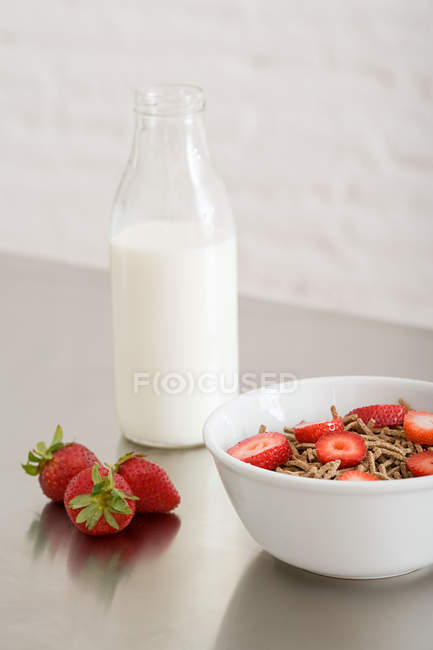 Tazón de cereal y botella de leche - foto de stock