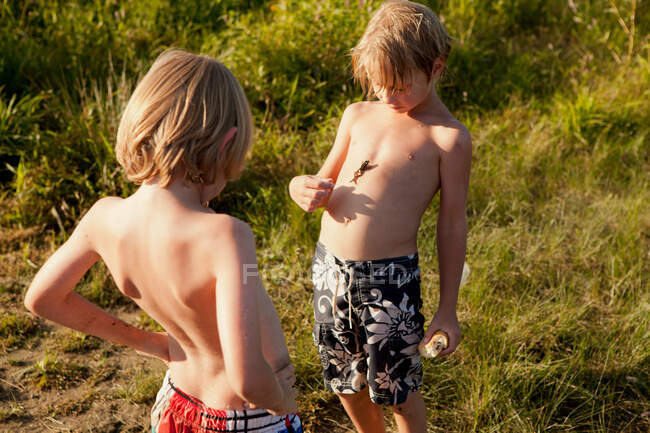 Deux garçons, un avec une grenouille sur la poitrine — Photo de stock