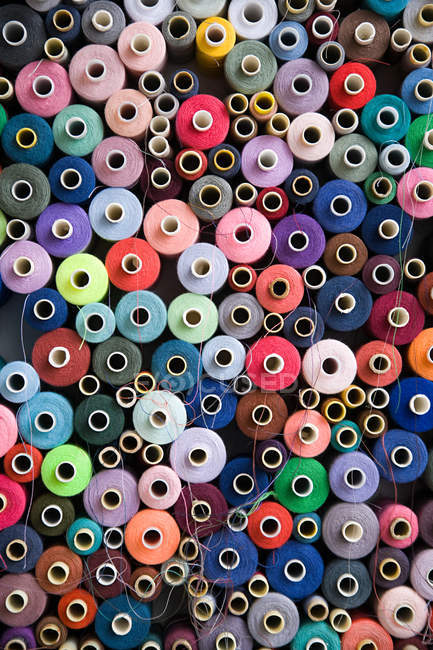 Pile of multi colored cotton reels — Stock Photo