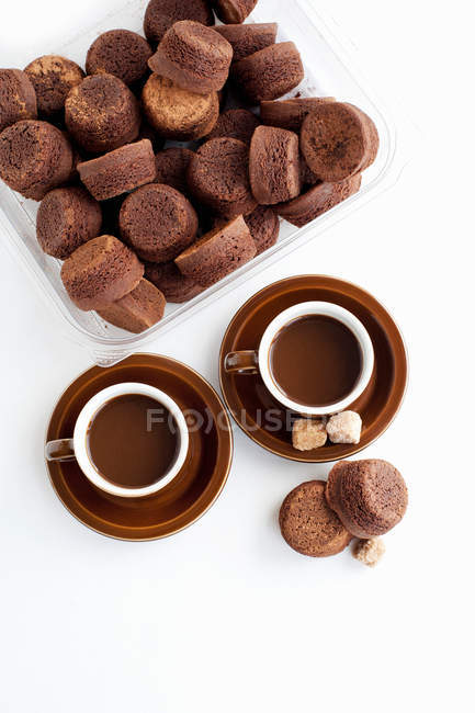 Café fresco en tazas con pasteles - foto de stock