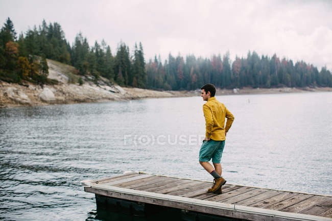Jeune homme marchant sur la jetée à Shaver Lake, Californie, États-Unis — Photo de stock