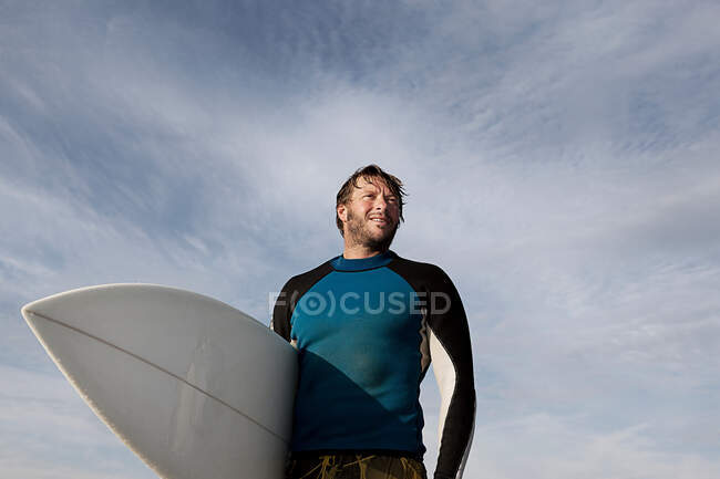 Surfer carrying board outdoors — Stock Photo