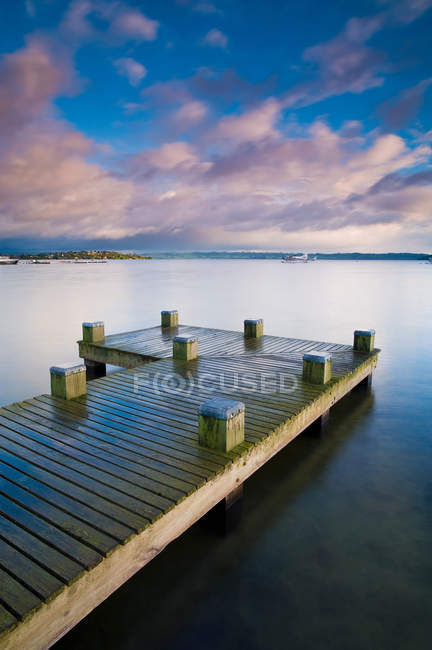 Cais de madeira em lago imóvel — Fotografia de Stock