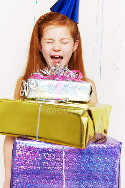 Chica gritando con pila de regalos de cumpleaños - foto de stock