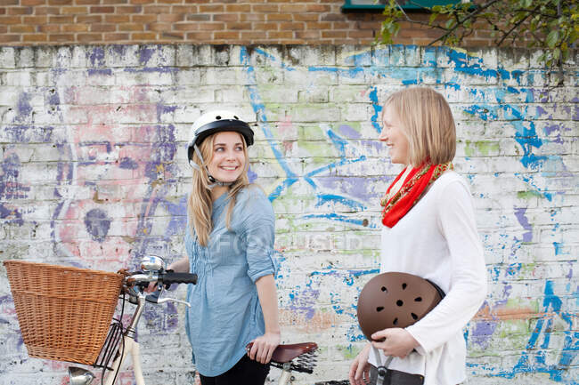 Mulheres em bicicletas na rua da cidade — Fotografia de Stock