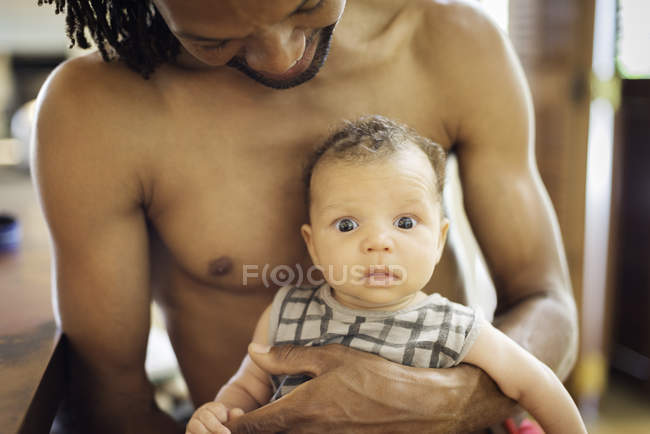 Father carrying baby in arms — Stock Photo