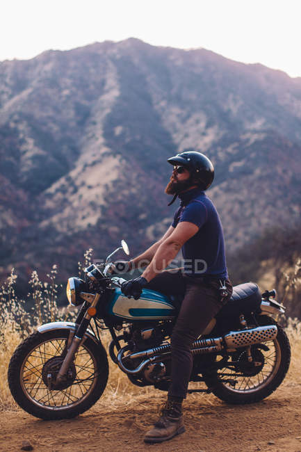 Людина сидить на мотоциклі, дивлячись на думку, Національний парк Секвойя, Каліфорнія, США — стокове фото