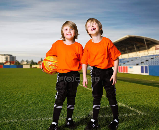 Meninos na equipe de futebol em pé em campo — Fotografia de Stock