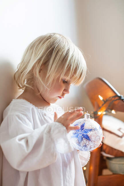 Girl fascinated with blue star bauble — Stock Photo