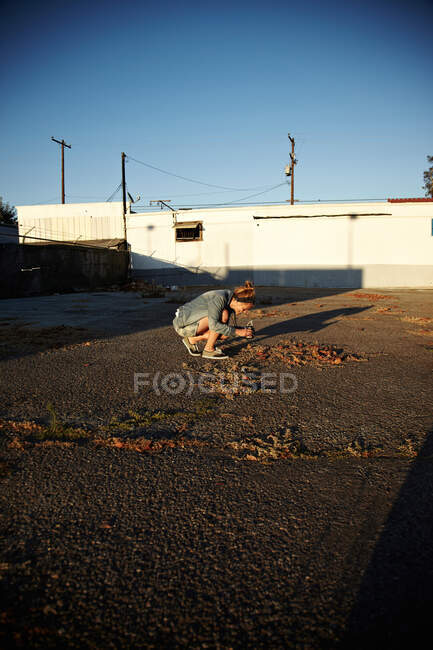 Woman bending down to take photograph — Stock Photo