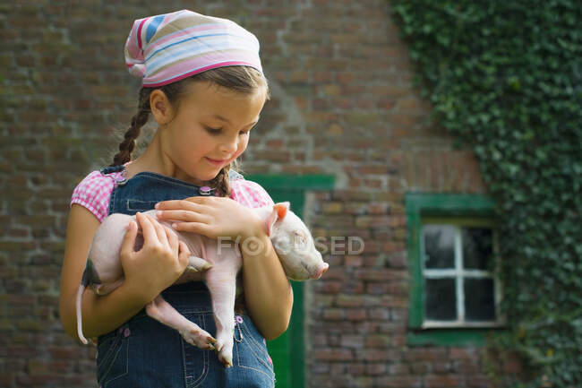 A girl holding a piglet — Stock Photo