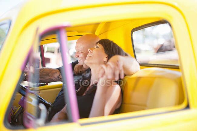 Пара сміється в барвистій машині. — стокове фото
