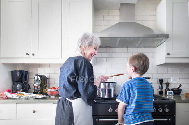 Avó e neto preparando comida em casa — Fotografia de Stock