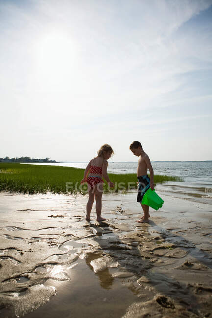 Menina e menino na praia na maré baixa — Fotografia de Stock