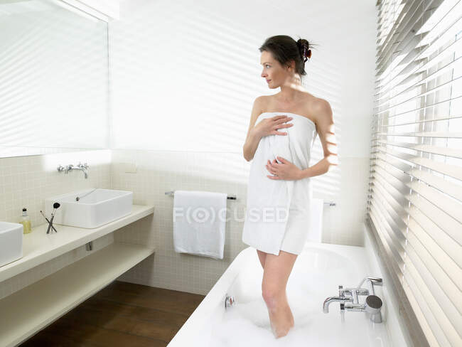 Mujer saliendo de la bañera - foto de stock
