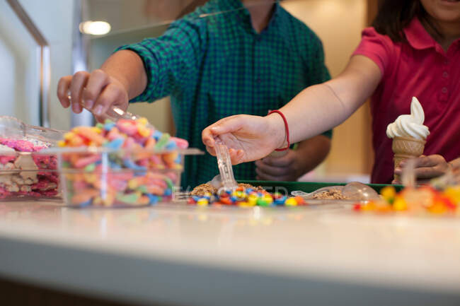 Children choosing toppings in store — Stock Photo