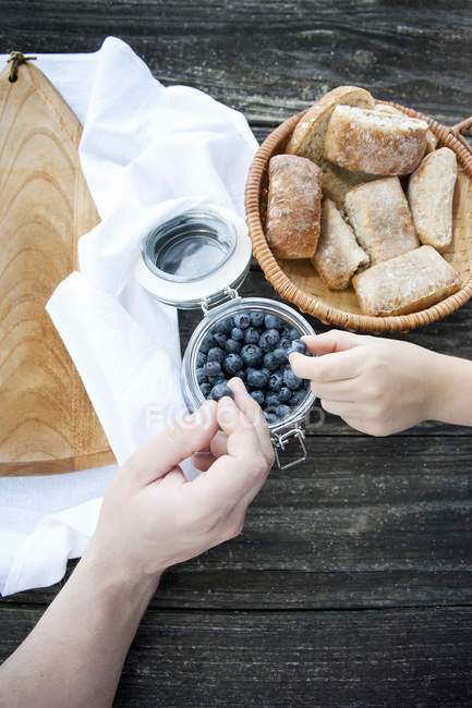 Cropped image of father and son taking blueberries from jar — Stock Photo