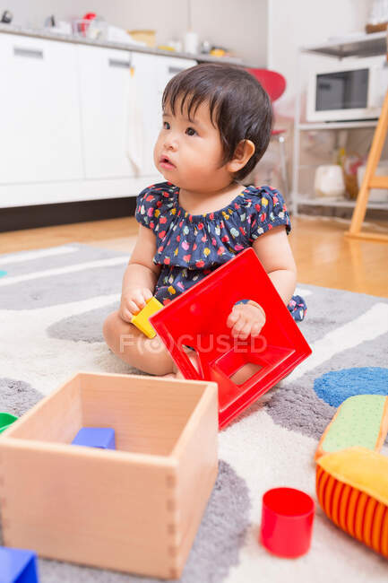 Bebé niña jugando en el suelo - foto de stock