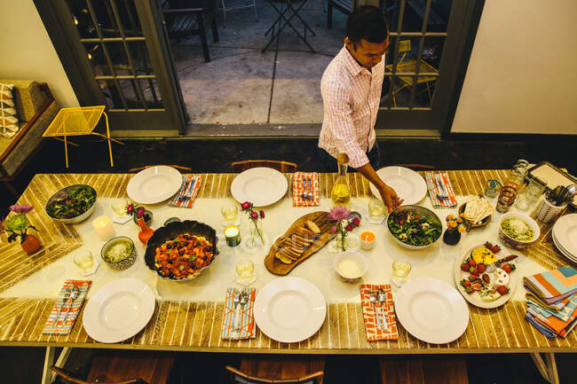 Uomo mettendo piatto sul tavolo da pranzo — Foto stock