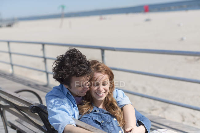 Casal romântico no banco do parque na praia — Fotografia de Stock