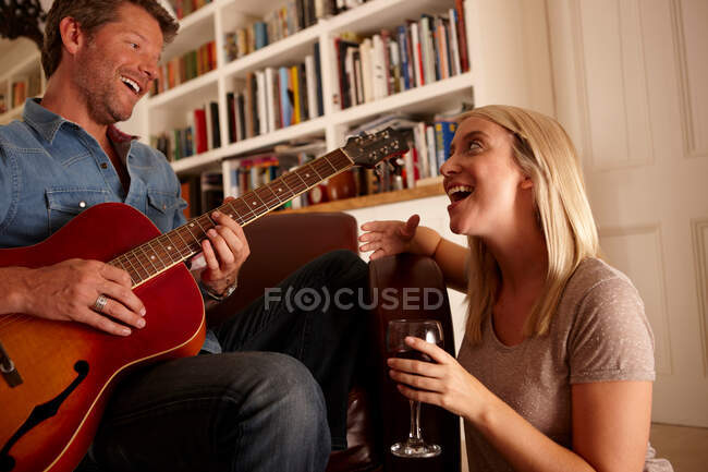 Чоловік грає на гітарі, жінка співає — стокове фото