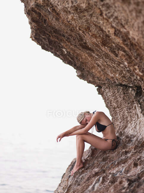 Жінка сидить на скелях — стокове фото