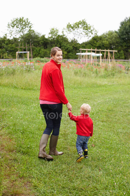Mãe e filho caminhando no campo — Fotografia de Stock
