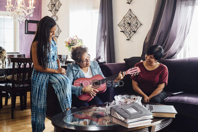 Avó tocando guitarra para a família — Fotografia de Stock